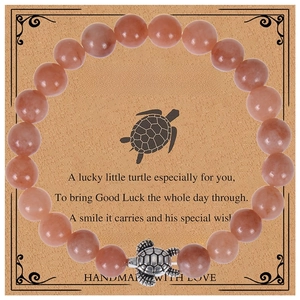Close-up of 8mm orange beaded turtle bracelet on a decorative handmade gift card