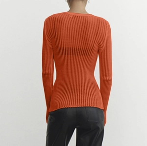 Rear view detail of bright orange slim fit long sleeve knit top with vertical ribbed texture