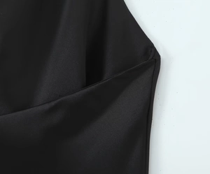 Detailansicht des glatten schwarzen Satinstoffs und der feinen Nähte am Minikleid