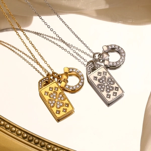 Detail of horseshoe clasp and clover rectangular pendants in 18K gold and silver finish