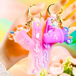 Detailed close-up of pink and purple milk tea cup keychains with stylish wrist straps