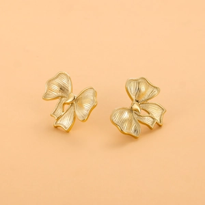 Boucles d'oreilles nœud plaquées or 18 carats avec une texture en métal brossé
