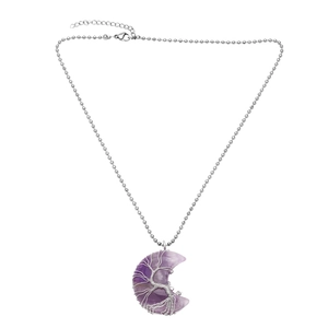 Macro shot of silver wire-wrapped tree of life on purple moon crystal pendant necklace