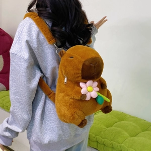 Cute Capybara plush backpack with pink flower accessory shown worn on a model's back