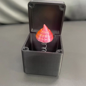 Dettaglio scatola nera stampata in 3D con personaggio emoji a molla per regalo scherzo