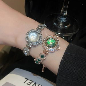 Detailed macro view of diamond-encrusted bracelet watches in silver and rose gold finishes