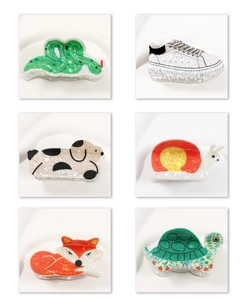 Vue détaillée en grille de diverses pinces à cheveux en PVC aux motifs d'escargot et renard