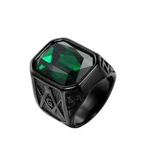 Vista macro dell'anello in acciaio nero con gemma verde e incisione massonica