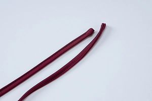 Macro shot of fine stitching and wine red elastic knit fabric on backless dress