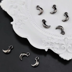Macro detail of crescent moon alloy pendant with vintage silver finish for DIY jewelry