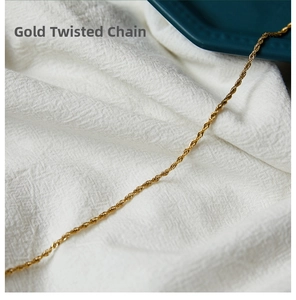 Close-up of a 12 gold plated stainless steel twist rope chain on white fabric