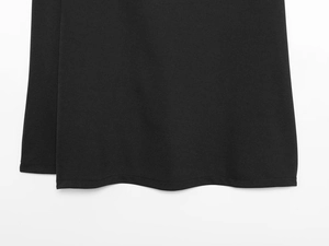 Detailed macro view of the double-stitched hem and fabric texture of black midi skirt