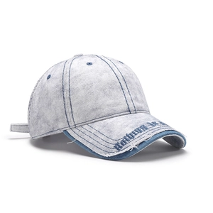 Washed blue denim baseball cap with embroidered lettering and adjustable strap