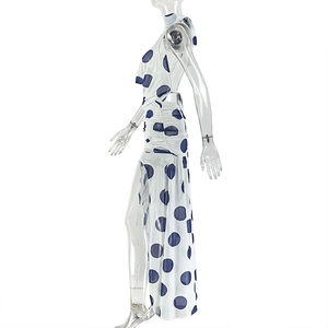 Detailed side view of white halter neck maxi dress with blue polka dots and open back design
