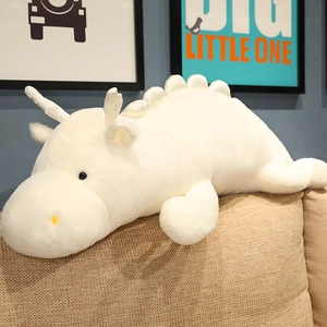Detail of soft white dragon plush toy lying on a sofa for cozy home decoration