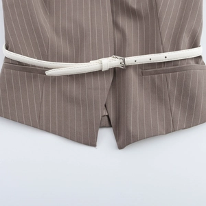 Detail of grey striped vest showing white slim leather belt with silver buckle and fabric texture