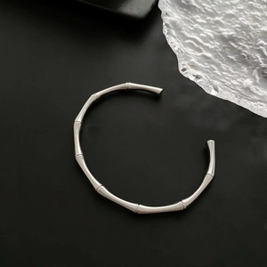 Macro detail of a silver bamboo joint open bangle with a matte metallic finish
