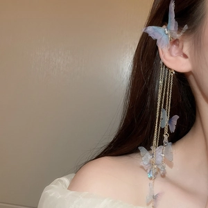 Détail d'un ear cuff papillon bleu et violet avec de longues chaînes de glands dorés