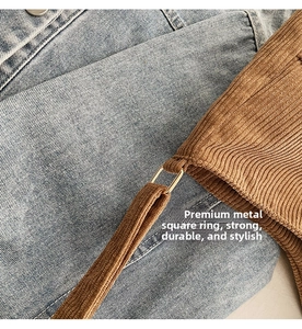 Close-up of golden metal buckle on brown corduroy shoulder bag with fine texture