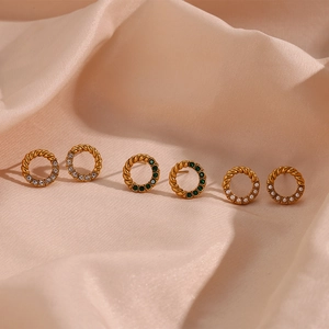 Macro shot of three pairs of vintage gold twist hoop earrings with pearls and emerald gems