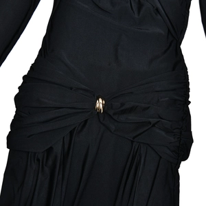 Detail of waist ruching on a black slim dress with a golden ring buckle decoration