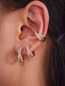 Macro view of gold-plated criss-cross earrings with micro-pave white zircon stones