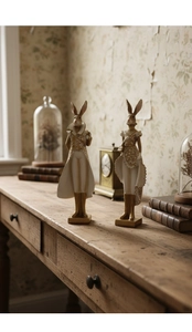 Detailed close-up of rabbit statues in Victorian style with golden floral relief patterns