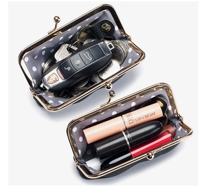 Detail showing internal capacity of the mini black leather coin purse with cosmetics