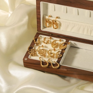 Selection of 18K gold plated stainless steel earrings on a luxurious silk background