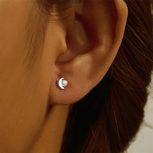Close-up of S925 sterling silver crescent moon ear stud with white opal on ear