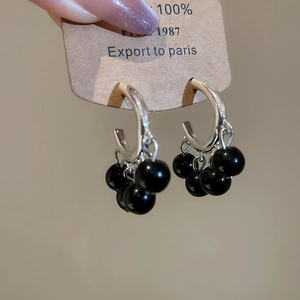 Detailed shot of vintage silver hoop earrings with dangling black polished beads