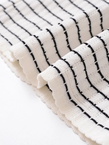 Gros plan sur la texture du tricot à rayures noires et blanches aux plis naturels