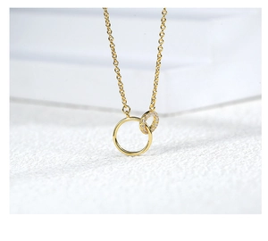 Close-up of interlocking double circle necklace pendant with pavé-set crystals in gold finish
