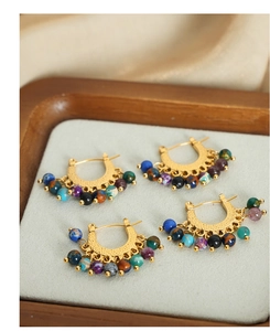 Détail de boucles d'oreilles bohèmes dorées avec des perles d'agate colorées