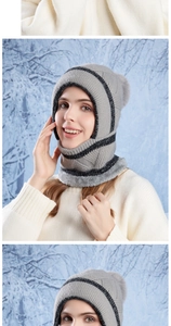 Close-up of winter knitted integrated hat with thick fleece lining and grey faux fur pompom