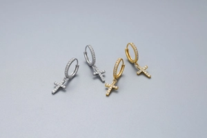 Detail of S925 sterling silver cross hoop earrings with sparkling zircon inlay in gold and silver