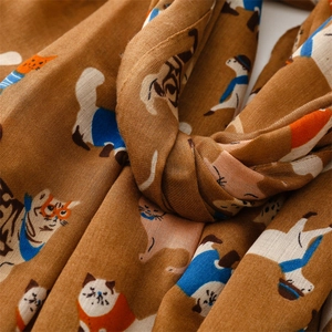 Close-up of lightweight brown cotton-linen scarf with colorful cartoon cat patterns