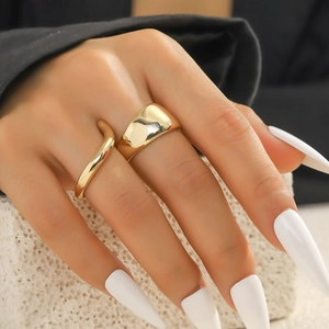 Nahaufnahme eines goldenen Ring-Sets mit glattem breitem Band und Wellendesign