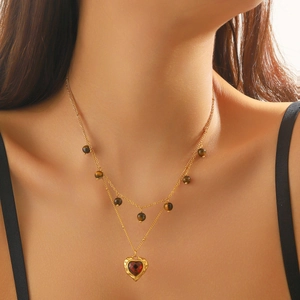 Double-layered tiger eye beaded gold necklace with heart gemstone pendant on a model