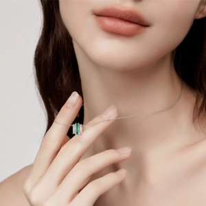 S925 silver necklace with emerald pendant and pavé stones on a female model