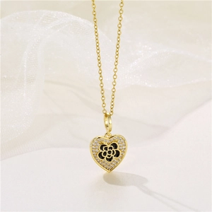 Golden heart necklace with black camellia flower and zircon pendant on a soft fabric