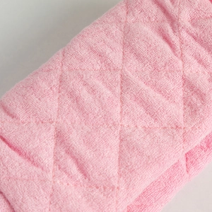 Macro shot of pink quilted terry cloth cosmetic bag showing soft fiber texture