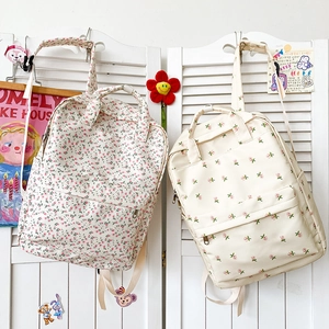 Floral canvas backpacks with multiple zipper layers and adjustable straps shown in detail