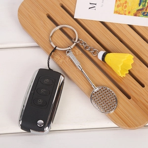 Close-up of silver metal badminton racket and yellow shuttlecock sports keychain