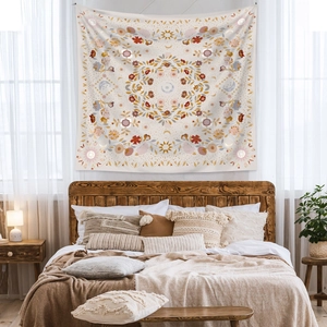 Close-up of bohemian mandala tapestry featuring warm orange and purple floral patterns