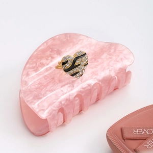 Macro shot of gold-plated heart ring with zebra pattern enamel and pavé rhinestones