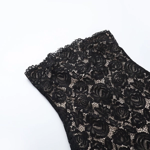 Détail d'une robe de plage en dentelle noire avec broderie de roses et texture en maille