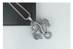 Macro view of detailed winged dragon pendant with a silver steel box chain necklace