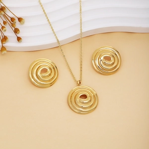 Golden spiral metal jewelry set with necklace and stud earrings on an elegant background