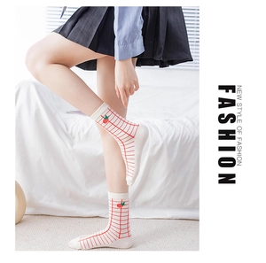 Detail of white cotton crew socks with red plaid pattern and strawberry embroidery